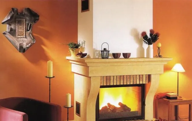 Cette cheminée conçue en pierre de Dordogne et briques vieillies apportera un charme d'antan à votre salon. © Godin