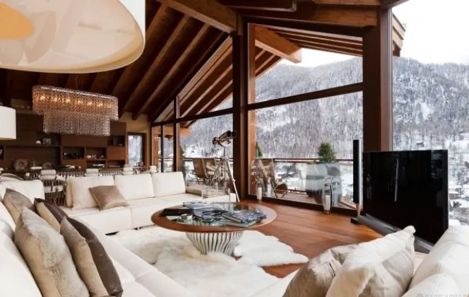 Magnifique salon avec vue panoramique sur la montagne enneigée DR