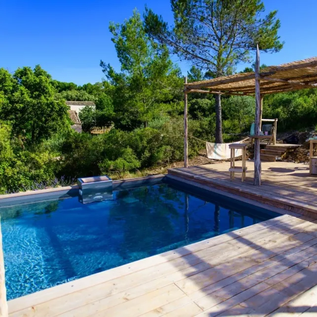 La terrasse de cette piscine en bois s'intègre dans le paysage provençal rustique