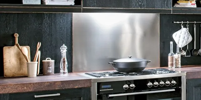 Une crédence de cuisine en inox installée au dessus du plan de cuisson